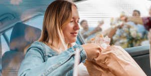 Woman eating in car, as life speed by her. Friends eating together while she's eating alone and on the go