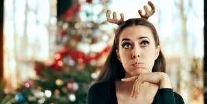 woman with reindeer antlers with christmas tree