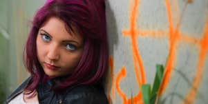 teen girl standing against a wall