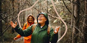 Woman hiking in nature, as it rains, embracing the weather