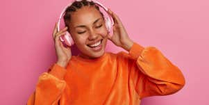 young woman with headphones on listening to songs about life