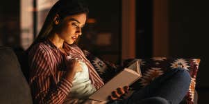 girl reading book in bed