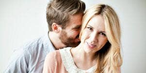 man kissing woman's neck