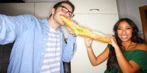 man and woman sharing a sub sandwich