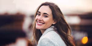 woman smiling at camera with blurry background