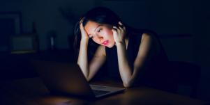 woman in black staring at a screen
