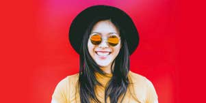 woman wearing vintage sunglasses red background
