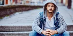 man wearing a hoodie sitting on stairs