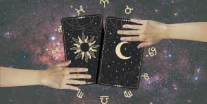 hands reaching for tarot cards