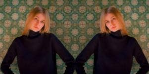 serious faced blonde haired woman wearing black sweater
