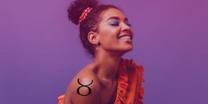 woman wearing blue eyeshadow with taurus tattoo on shoulder
