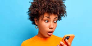 woman looking at her phone shocked by texts
