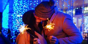 couple kissing holding sparklers on new years