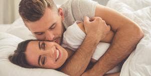 man and woman cuddling in bed