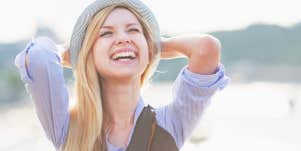 young blonde woman smiling in hat