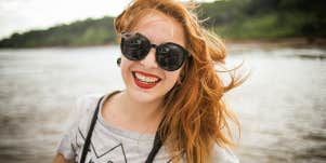 happy woman smiling wearing sunglasses