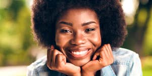 Confident, happy woman smiles toward viewer.