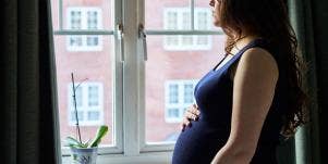 pregnant woman looking out window