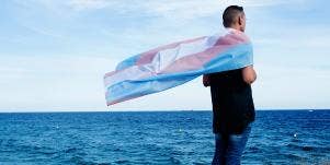 man standing near lake with flag