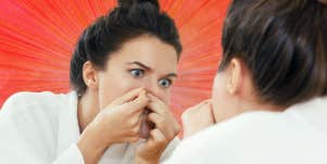 woman popping a pimple