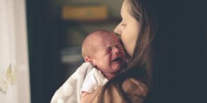 woman holding crying baby