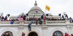 rioters climb the walls of the Capitol building on January 6, 2021