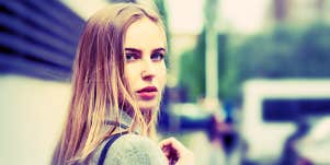 woman looking over her shoulder, nervously