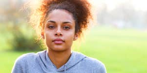 Confident young woman looks straight at camera