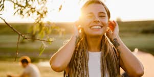 vibrant blonde woman with long hair laughing in the sun 