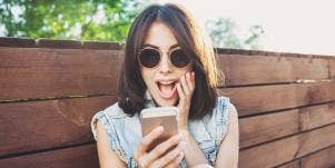 happy woman looking at her smartphone