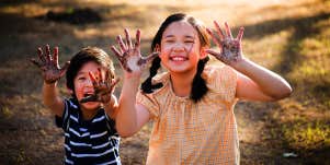 brother and sister with messy hands after playing outside