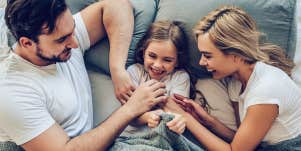 parents and kid in bed