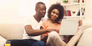 couples looking at laptop in the couch 