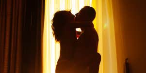 couple kissing in front of window