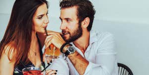man and woman sharing drink