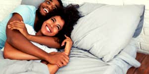Man embracing woman in bed happily