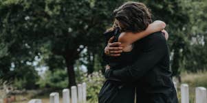people hugging at cemetery 