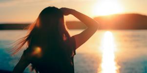 woman looking at ocean sunset