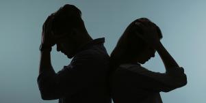 couple facing away from each other dark background