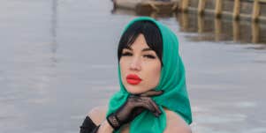 woman in green headscarf pouting