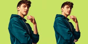 man looking at camera playing hard to get in front of green background