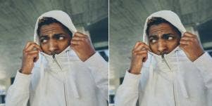 man pulling hoodie up over head and face