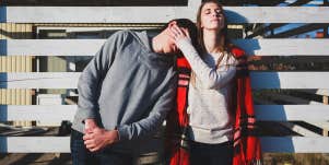 woman putting hand on man's cheek standing against gate