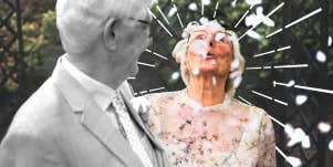 Older couple together blowing falling flowers 