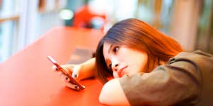 woman looking at her phone waiting for a guy to call