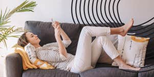 woman sitting on her couch exchanging flirty messages to her husband