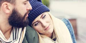 woman leaning her head on man's shoulder