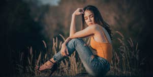 woman sitting alone in field