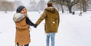 man and woman holding hands in the snow