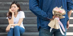 Woman upset while boyfriend gives her flowers